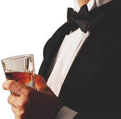 guy in a suit and bow tie holding a glass of whisky